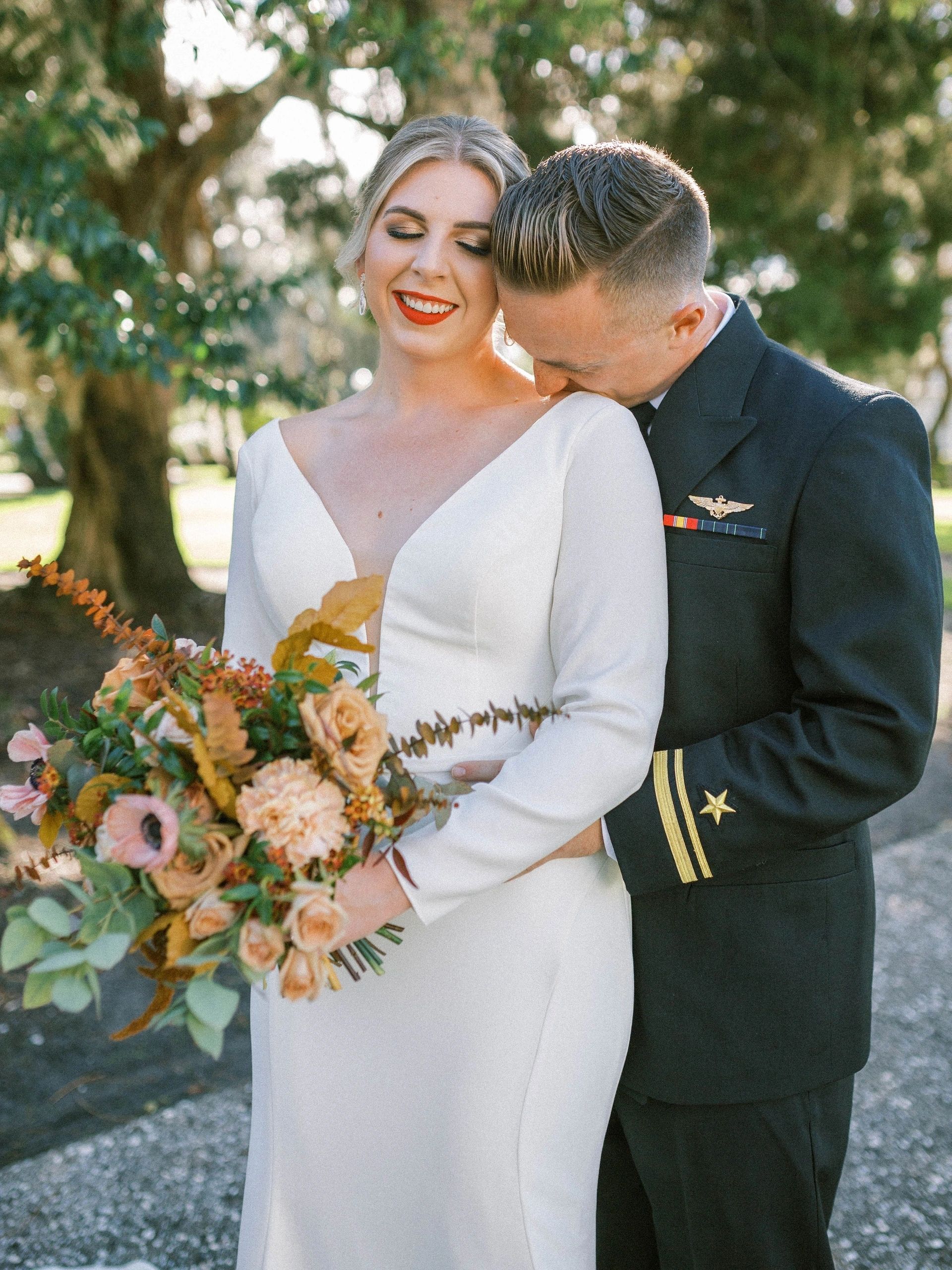 Bride in white long-sleeved gown with autumn bouquet, garden wedding portrait